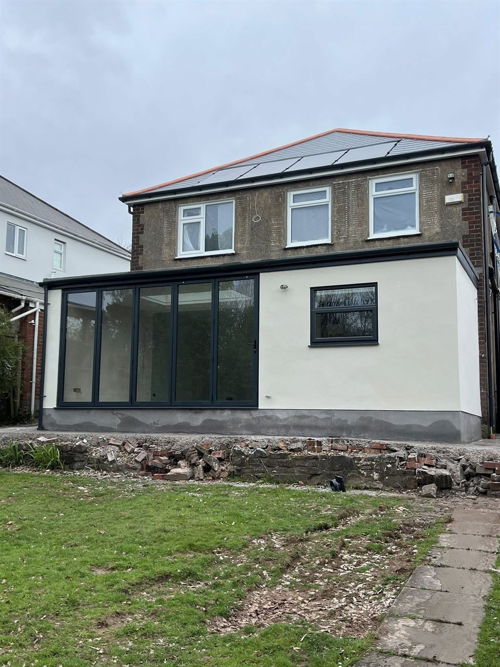 Finished white-rendered orangery extension with bi-fold doors