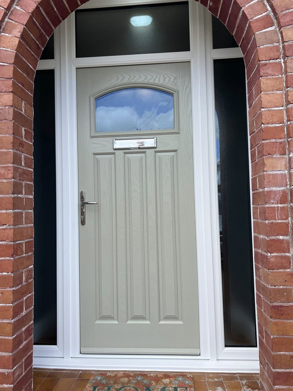 Cream composite front door set under a red brick archway